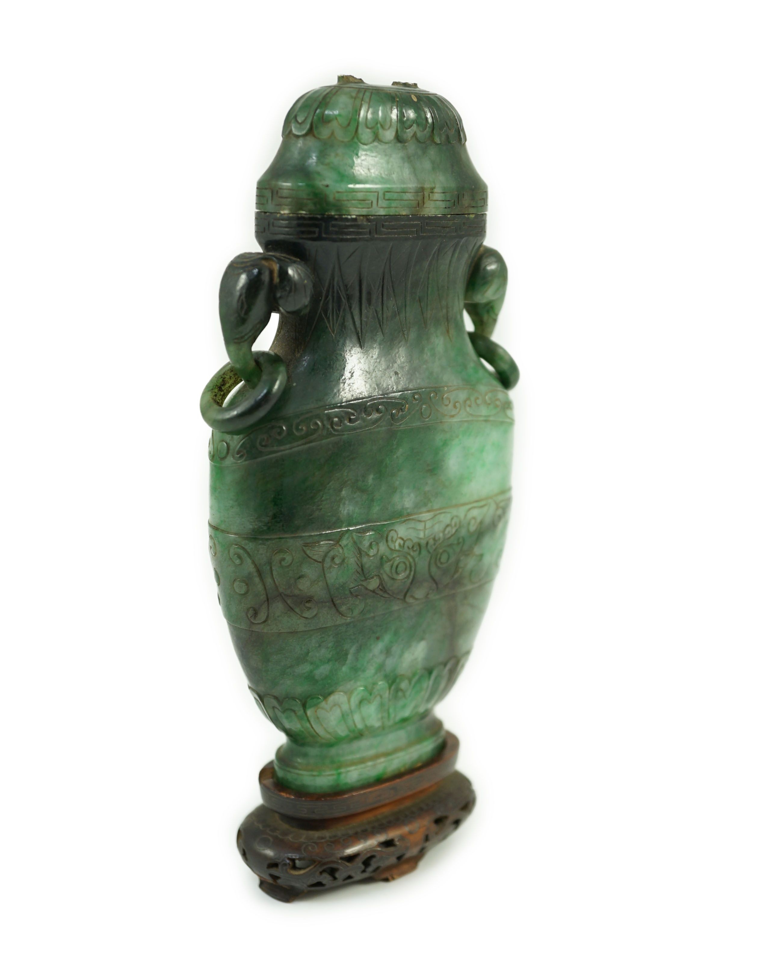 A Chinese archaistic green jadeite vase and cover, late Qing dynasty, 14.5 cm high, Silver wire inlaid wood stand, cover finial missing